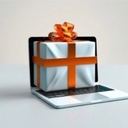 Ein Laptop auf einem angedeuteten Tisch mit einem Geschenkpaket als Synonym für verschenktes Wissen